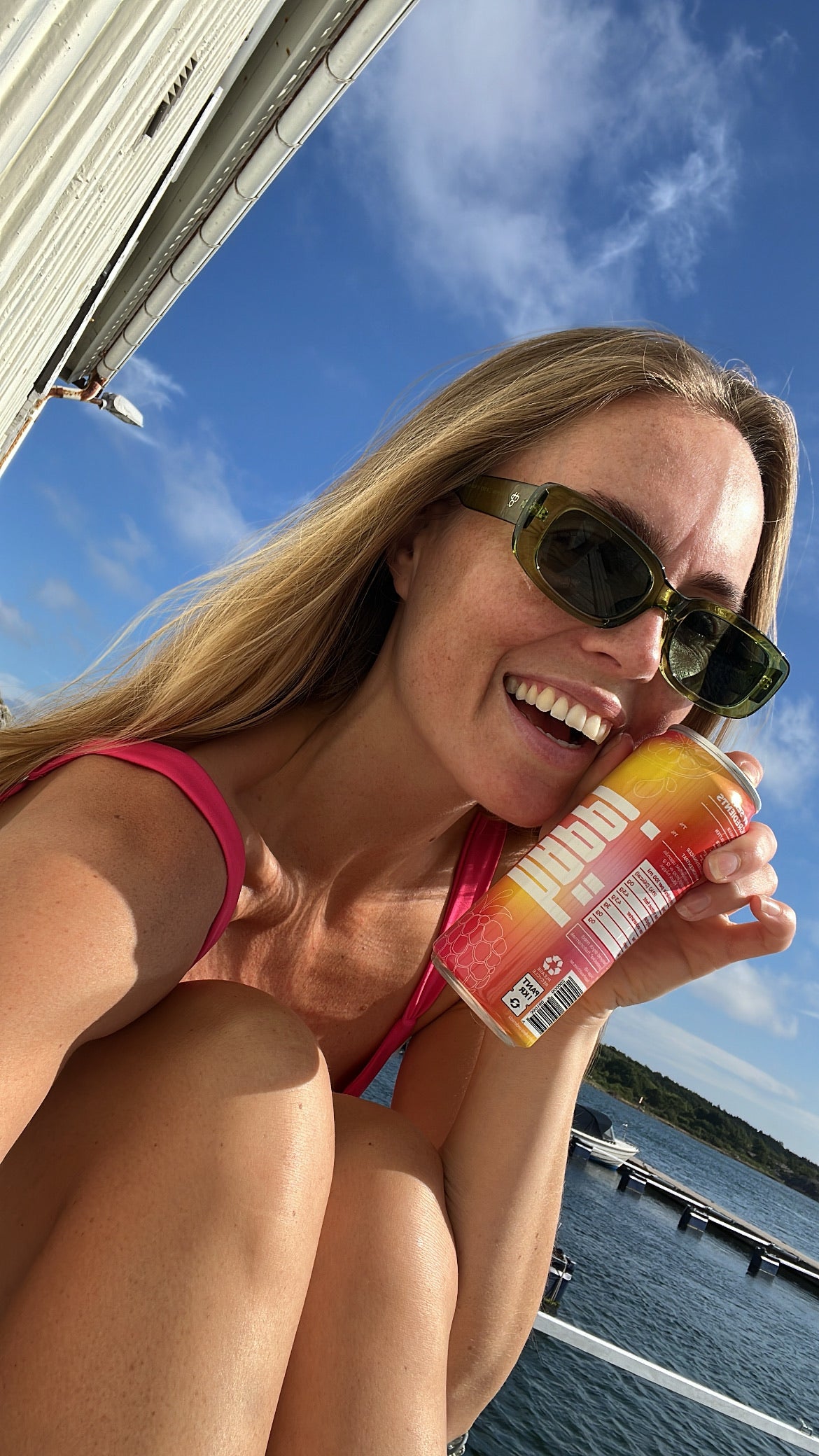 Smiling girl holding a can of hÄppi prebiotic soda, enjoying a refreshing drink that boosts mood and supports gut health